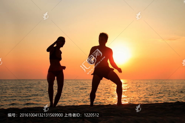 在日落的時(shí)候在海灘上跳舞