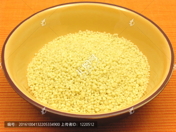 在橘子碗陶瓷在橙色背景黃蒸粗麥粉
