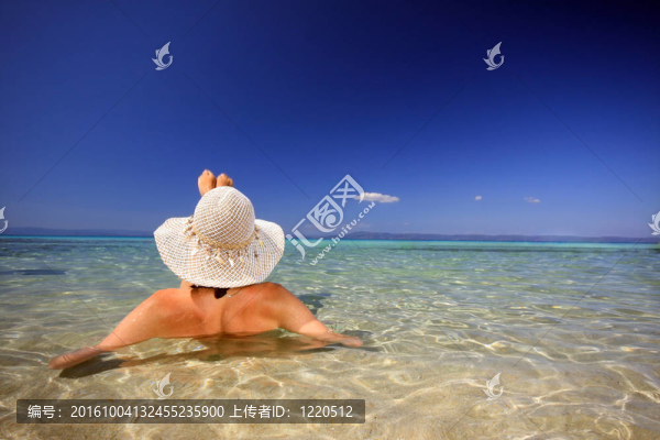 曬黑的金發(fā)女人穿著比基尼在海