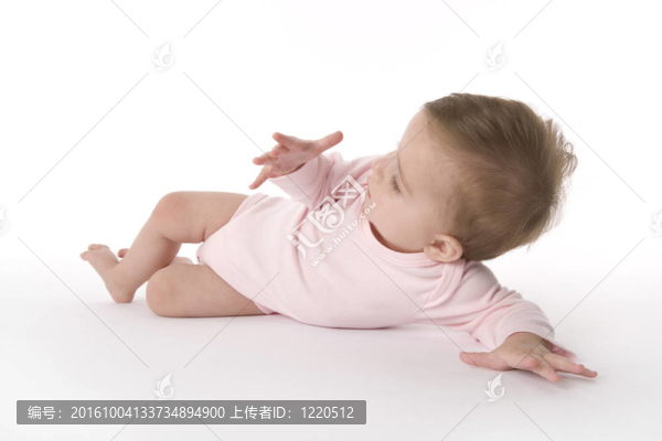 女嬰躺在地板上看著自己的手
