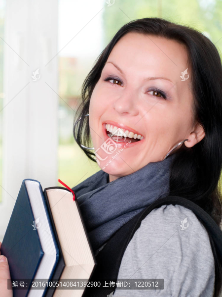 微笑的學(xué)生婦女拿著書