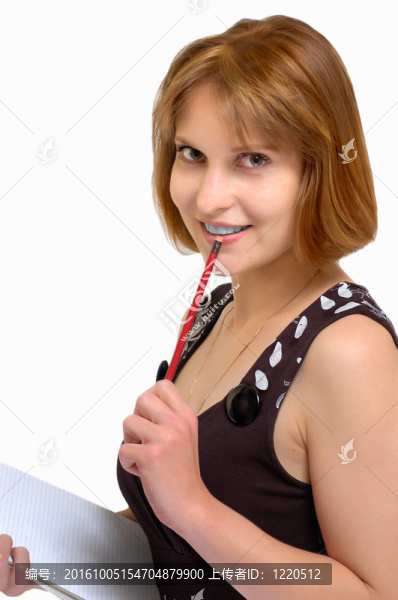 迷人的女人手拿鉛筆和筆記本（灰色背景）