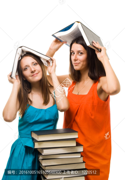 兩個(gè)年輕的學(xué)生女人玩書(shū)