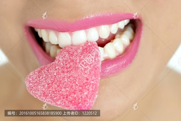 女性宏觀嘴上的心形糖果