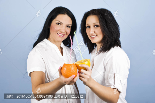 兩個年輕的女人喝柑橘汁
