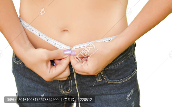 女性衡量她的腰圍；磁帶運動飲食修剪。