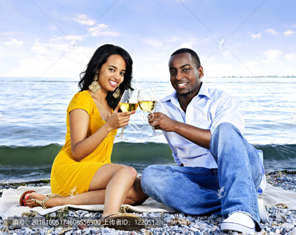 在海灘上有酒的幸福的夫婦