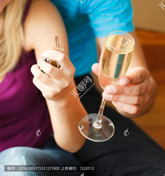 一對夫婦抱著一把鑰匙和一杯香檳。買房子的概念