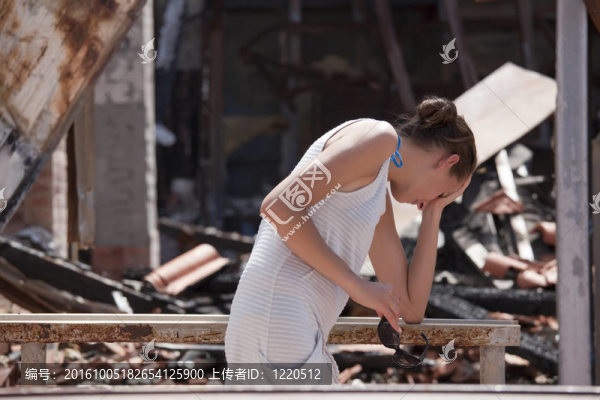 傷心的女人和被燒毀的房子