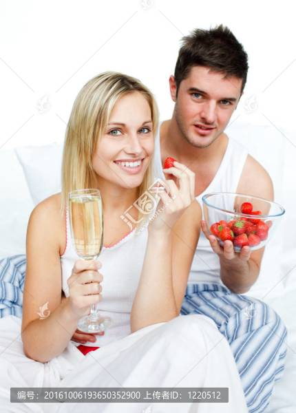 夫婦慶祝與草莓和香檳在床上訂婚