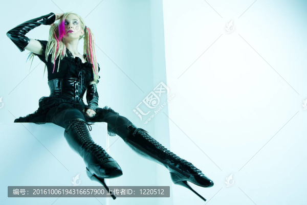 與辮子穿奢侈的衣服和靴子的年輕女子