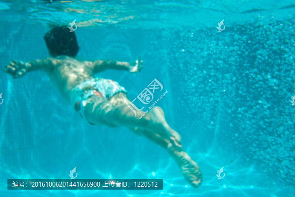 小男孩在游泳池里游泳
