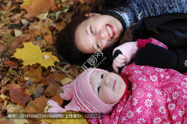 媽媽帶著女兒走在秋天的公園里