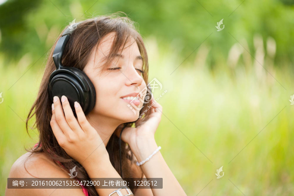 帶耳機(jī)的年輕女性-匯圖網(wǎng) www.fosd68.com 帶耳機(jī)的年輕女性