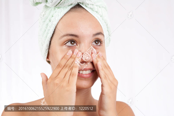 年輕的女人在她的臉上涂奶油