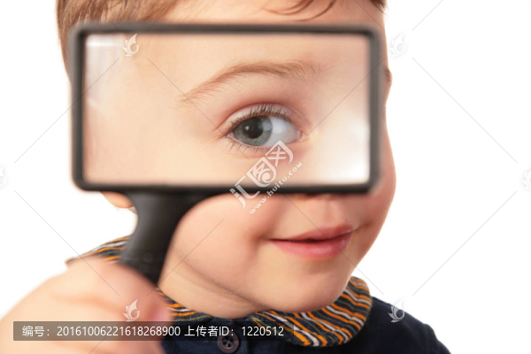 微笑的孩子透過放大鏡