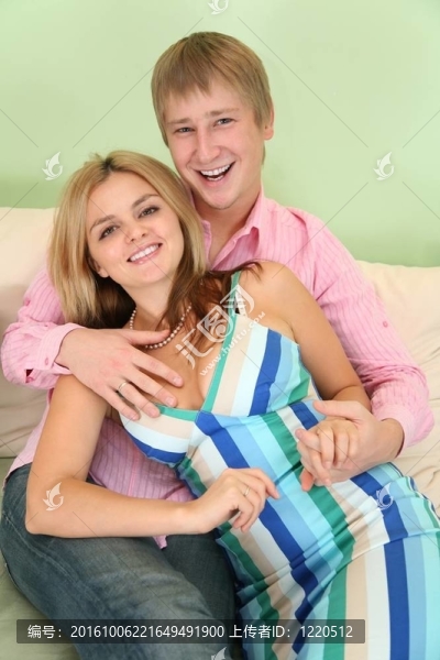 在綠色房間里的年輕夫婦在沙發(fā)上