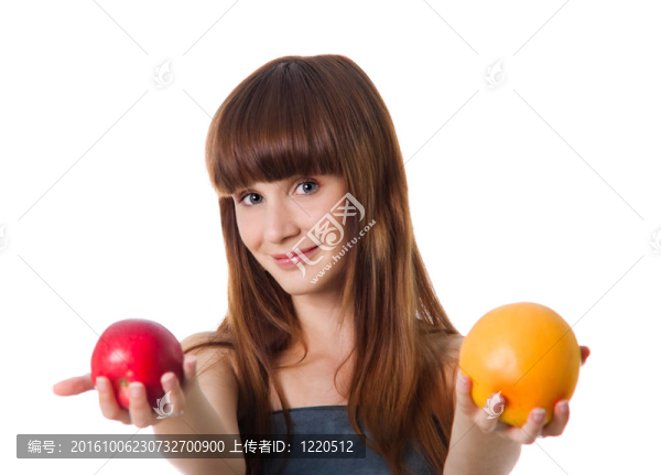漂亮的女人拿著蘋果和橘子