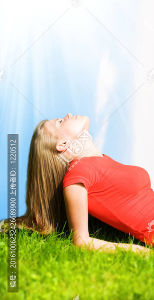 年輕的女人在綠草上休息