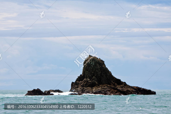 巖石島在海洋與樹木和藍天