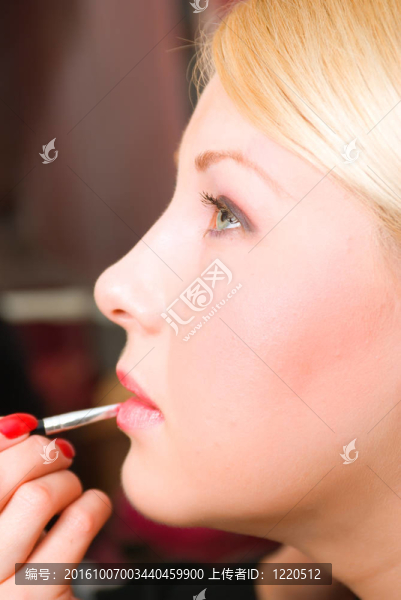 這女孩的嘴唇用紅色唇膏美容師