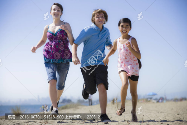 三個孩子在Beach上跑步