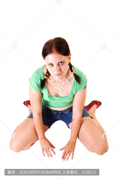 漂亮女孩短褲跪在地板上。