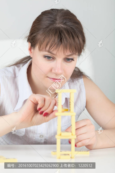 年輕的女孩建立多米諾骨塔表