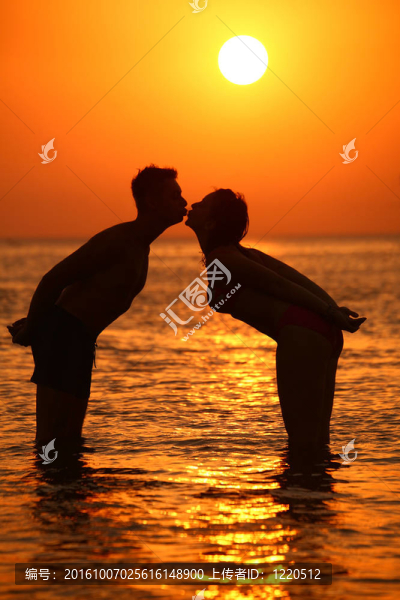 夕陽中的情侶剪影吻