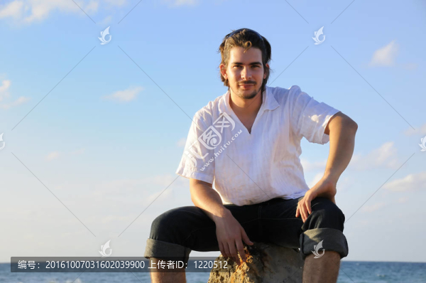 坐在海邊的英俊男子
