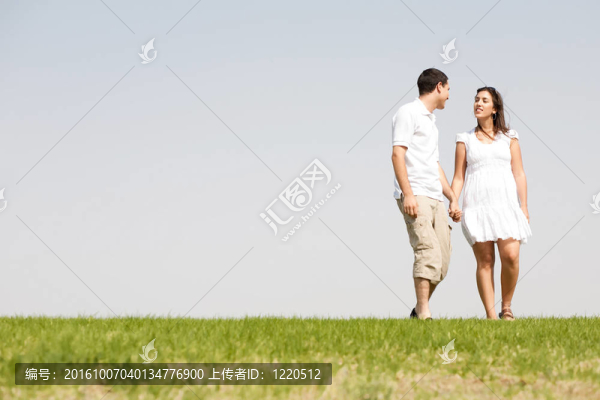 可愛的年輕夫婦手牽手散步