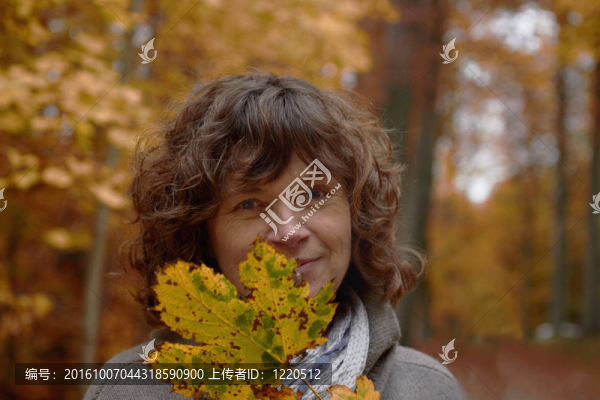 秋中年女人看著你身后的楓葉