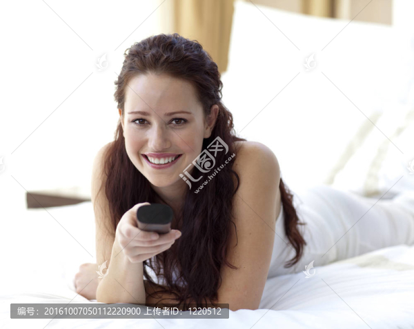 美女在臥室里拿著遙控器