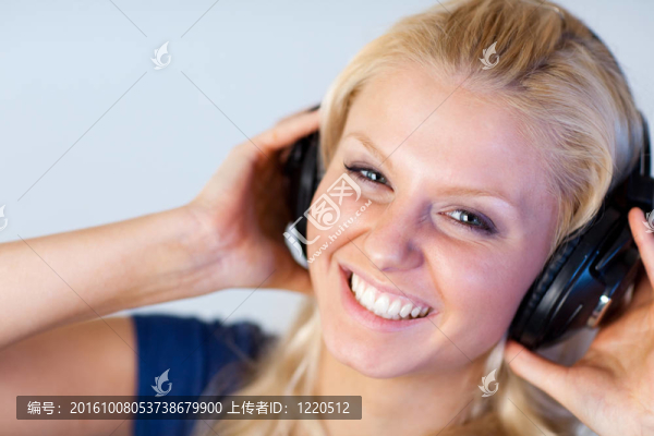 快樂女人用耳機(jī)聽音樂