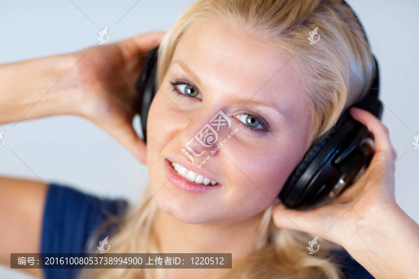 金發(fā)女人用耳機聽音樂