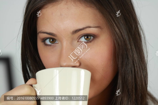 漂亮臉蛋的年輕女人正在喝茶/喝咖啡