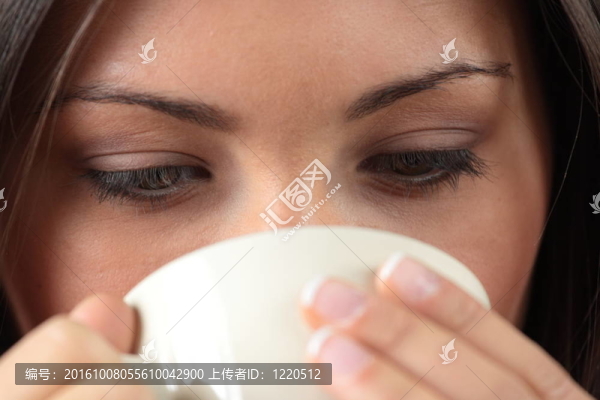 漂亮臉蛋的年輕女人正在喝茶/喝咖啡
