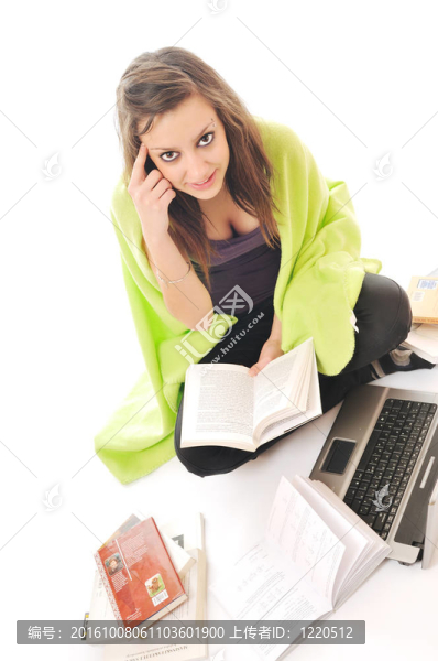 一個年輕女孩在白色的筆記本電腦上工作