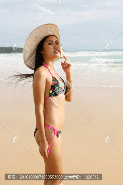 在海灘上，在一個明亮的比基尼美麗的亞洲女子。