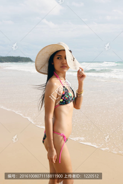 在海灘上，在一個明亮的比基尼美麗的亞洲女子。