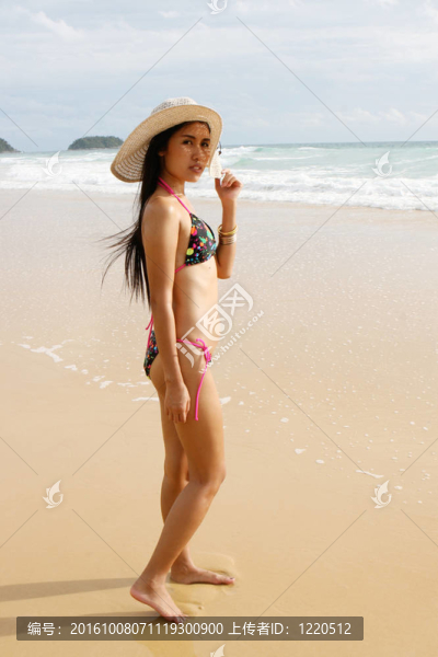 在海灘上，在一個明亮的比基尼美麗的亞洲女子。