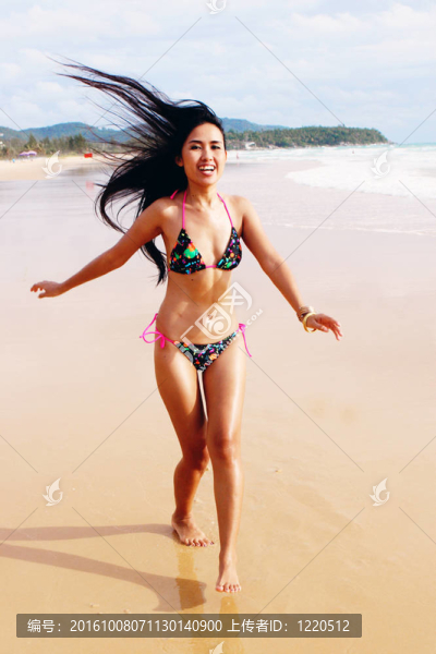 在海灘上，在一個(gè)明亮的比基尼美麗的亞洲女子。