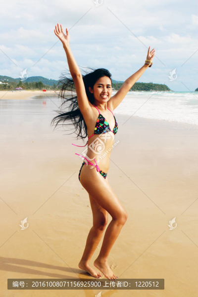 在海灘上，在一個(gè)明亮的比基尼美麗的亞洲女子。