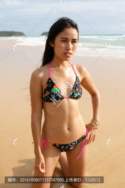 在海灘上，在一個(gè)明亮的比基尼美麗的亞洲女子。
