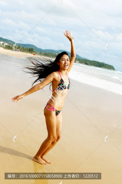 在海灘上，在一個明亮的比基尼美麗的亞洲女子。