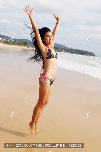在海灘上，在一個明亮的比基尼美麗的亞洲女子。