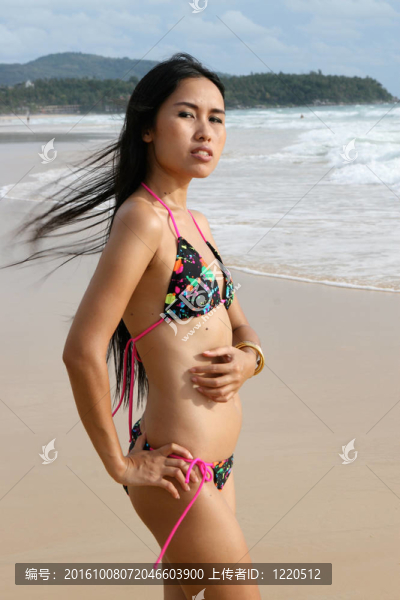 在海灘上，在一個(gè)明亮的比基尼美麗的亞洲女子。