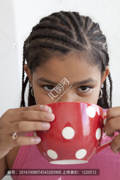 小女孩正在喝一大杯茶