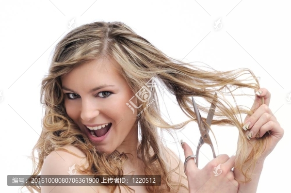 微笑的年輕女人用剪刀剪頭發(fā)