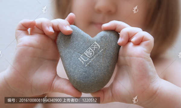 孩子的手中握著一塊石頭的心